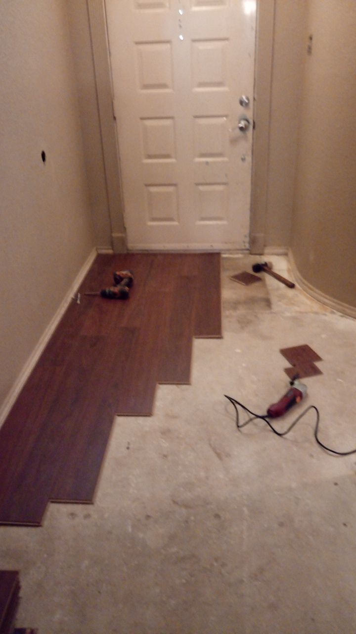 Laminate plank flooring being laid at an entryway